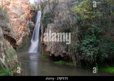 Unglaubliche Wasserfälle aus kristallklarem Wasser, die mitten im Herbst auf eine große Höhe fallen und von viel Vegetation umgeben sind Stockfoto