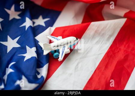 Reisen in die Vereinigten Staaten von Amerika. Leere Commercial Airplane mit vier Motoren, auf USA-Flagge im Hintergrund, Blick von oben. 3D-Darstellung Stockfoto