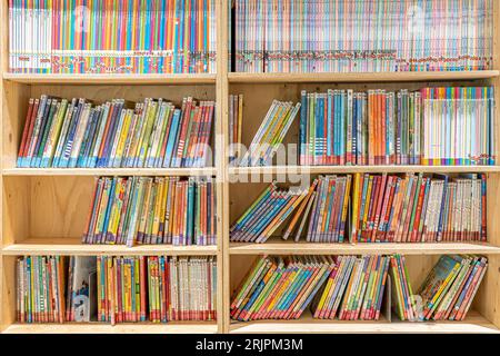 Eine gemütliche Bibliothek mit bunten Kinderbüchern Stockfoto