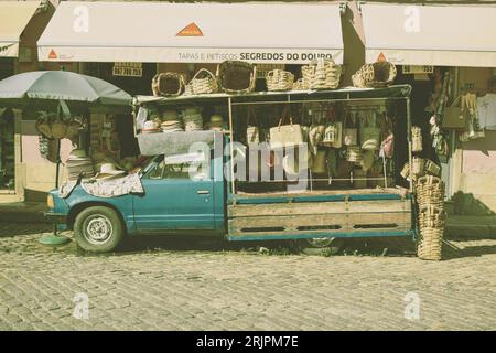Ein alter blauer Pick-up-Truck, der an einer Landstraße mit sanften Hügeln und klarem Himmel geparkt ist Stockfoto