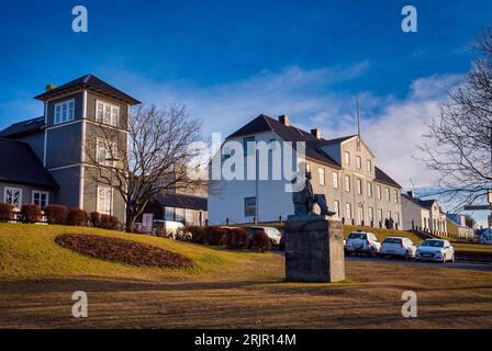 Foto einer Statue vor einem großen weißen Gebäude in Island Stockfoto