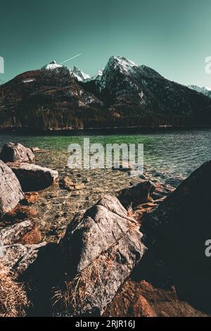 Eine Landschaft mit schneebedeckten Bergen und einem ruhigen See, umgeben von felsigem Gelände Stockfoto