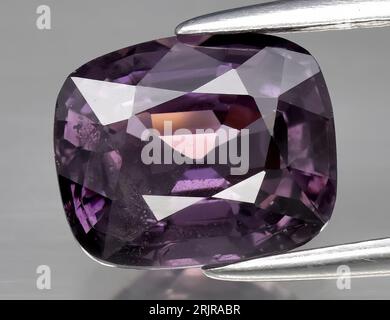 Natural gem purple spinel on gray background Stock Photo