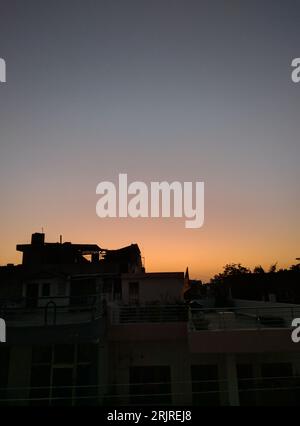 Ein malerischer Blick auf die Skyline der Stadt bei Sonnenuntergang mit Silhouetten von Gebäuden Stockfoto