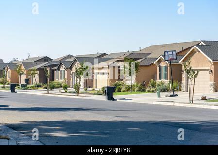 Detached houses along a street in a housing development on a clear autumn day Stock Photo