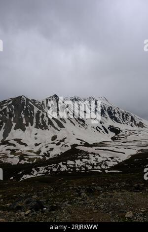 Dieses Stockfoto zeigt einen atemberaubenden Blick auf zwei schneebedeckte Berge mit einer weiten Weite weißen Schnees um sie herum Stockfoto