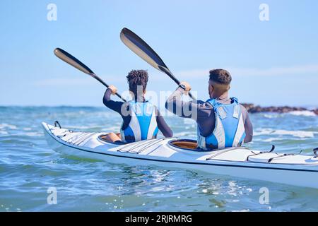 Wasser, Mann und Frau im Kajak und Sport auf See, Strand oder Fluss für gemeinsame Bewegung im Urlaub. Urlaub im Meer, Abenteuer und Fitness, Paare sind hier Stockfoto
