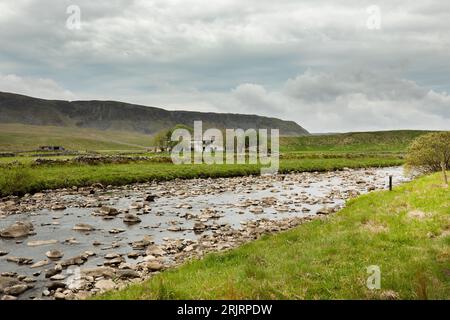 Cronkley Scar und Felsen der Whin Sill mit dem alten verlassenen Farmhaus von Wheysike House auf Harwood Beck nahe dem Zusammenfluss mit dem Fluss Tees Stockfoto