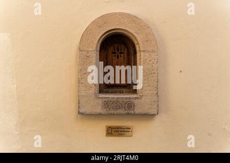 Eine Nahaufnahme eines Weinfensters an einer hellbeigen Wand, Florenz, Italien Stockfoto