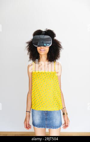 Junge Frau mit Virtual-Reality-Brille, weißer Hintergrund Stockfoto