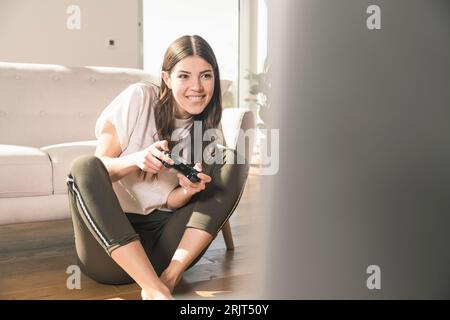 Glückliche junge Frau spielen video Spiel zu Hause Stockfoto