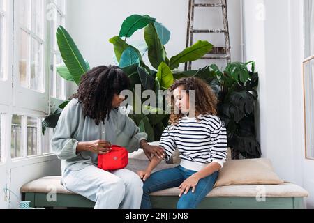 Mutter mit Verbandskasten zur Versorgung der verletzten Tochter Stockfoto