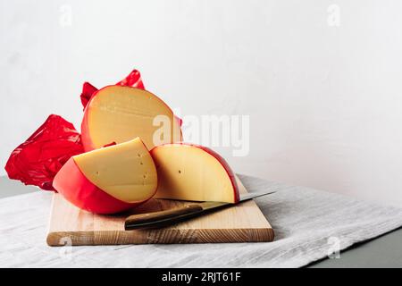 In Scheiben geschnittener Edamskäse, mit roter Wachsschicht bedeckt. Stockfoto