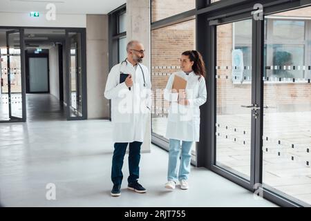 Arzt geht und spricht mit Kollegen auf dem Flur Stockfoto