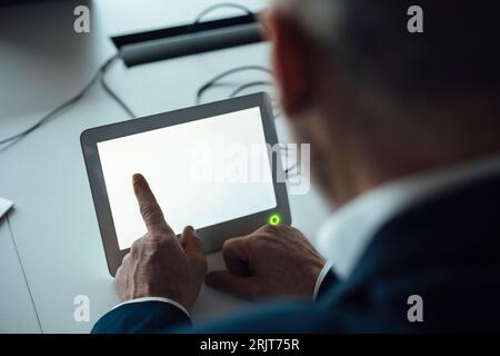 Geschäftsmann, der am Schreibtisch ein Tablet-PC verwendet Stockfoto