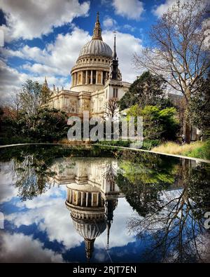 Ein majestätischer Blick auf die ikonische St. Paul's Cathedral in London, England, spiegelt sich in einem ruhigen Gewässer wider Stockfoto