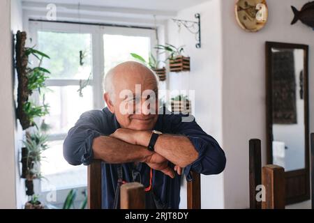 Der aufmerksame Senior Cafe Besitzer lehnte sich im Coffeeshop auf die Rückenlehne Stockfoto