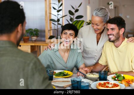 Glückliche Familie, die zusammen am Esstisch in der Küche zu Mittag essen Stockfoto