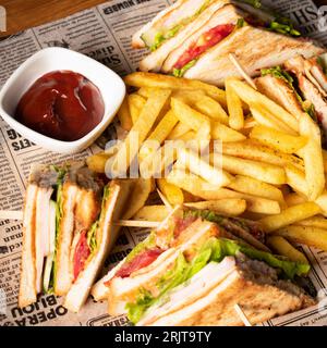 Eine Nahaufnahme eines Club-Sandwiches mit Pommes frites, serviert mit Ketchup Stockfoto