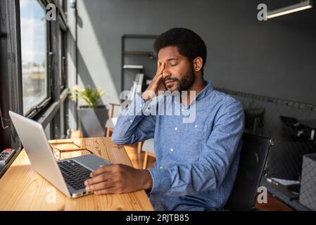 Müder Geschäftsmann macht Pause auf dem Stuhl im Büro Stockfoto