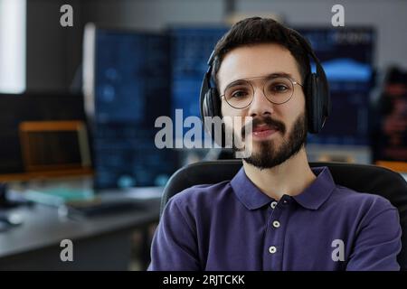 Lächelnd und professionell mit kabellosen Kopfhörern und Brillen im Büro Stockfoto