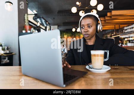 Fokussierte Geschäftsfrau, die im Café am Laptop arbeitet Stockfoto