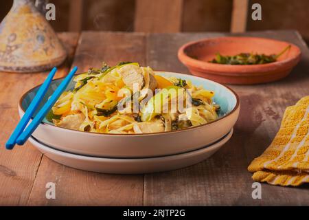 In rustikalem Ambiente mit Gemüse und Eiernudeln anbraten. Stockfoto