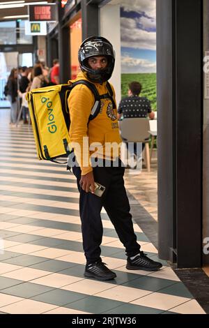 Glovo Food Delivery Motorradfahrer wartet auf die Abholung von Lebensmitteln Bestellung vor Fast Food Service in Fnac Einkaufszentrum, Aveiro, Portugal Stockfoto