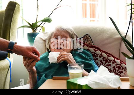 Ältere Dame im Alter von 103 Jahren Gefühl, ein Verwandter Hand in Care Home Großbritannien hundertjährigen 100 Jahre alt Stockfoto