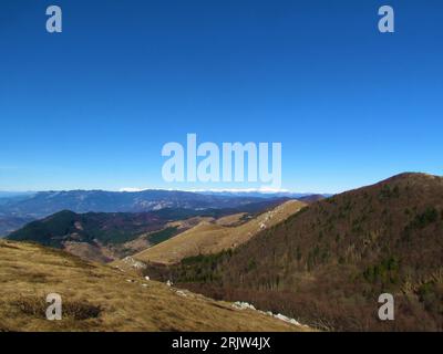 Blick auf schneebedeckte Gipfel der Julischen alpen im Rücken und die Hügel des Trnovo-Waldplateaus und des Nanos-Plateaus davor in Primorska oder der Küstenregion von Stockfoto