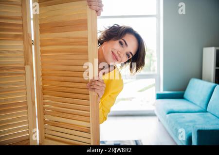 Foto einer positiven Dame, die Wochenenden im Einkaufszentrum hat, Kleidung im Ankleidezimmer wechseln, Holzfaltschirm Stockfoto