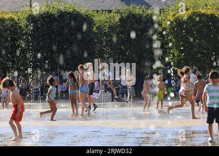 London, Großbritannien, 23. August 2023. Familien haben das heiße, sonnige Wetter in den Springbrunnen des Granary Square, Kings Cross, im Norden Londons optimal genutzt. Die Temperaturen stiegen schließlich nach einem miserablen Sommer, als die Schulferien kurz vor dem Ende standen Quelle: Monica Wells/Alamy Live News Stockfoto