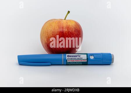 Ozempic Pen mit Apfel auf weißem Hintergrund mit Kopierraum Stockfoto