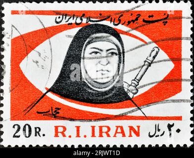 Frankierte Briefmarke, gedruckt vom Iran, die Frau mit Pistole zeigt, um 1981. Stockfoto