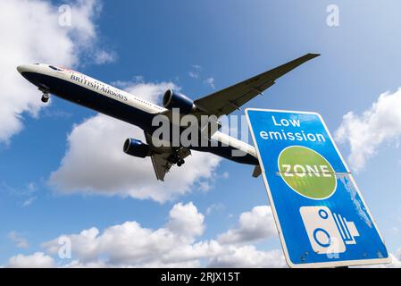 Schild für emissionsarme Zonen mit Landung eines Düsenflugzeugs am Flughafen London Heathrow, Großbritannien. Luftverschmutzung. Kohlendioxidemissionen. Luftverkehrsemissionen. Kamerabild Stockfoto