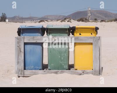 Recycle bins on a clean sand beach.  Reduces rubbish and helps save the planet Stock Photo