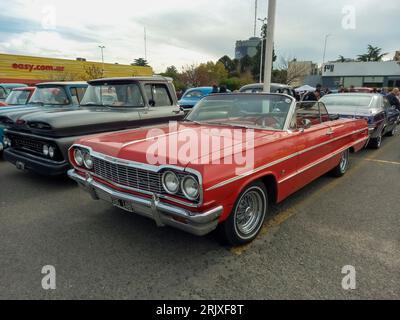 Old Red 1964 Chevrolet Chevy Impala SS Super Sport V8 zweitüriges Cabriolet von GM auf einem Parkplatz. Stockfoto