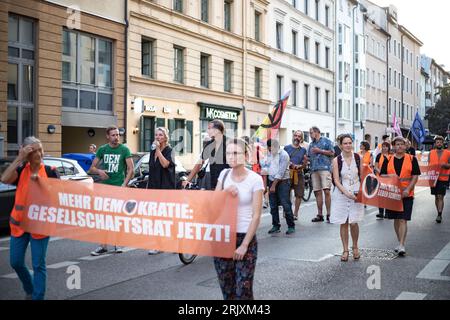 München, Deutschland. August 2023. Am 23. August 2023 versammelte sich die letzte Generation in München, um für den Klimaschutz zu demonstrieren. Am nächsten Tag beginnt die Bayern100-Phase in München. Damit will die letzte Generation München zum Stützpunkt des Protestes machen. Die letzte Generation fordert eine Geschwindigkeitsbegrenzung von 100 km/h auf Autobahnen, die Einführung eines neun-Euro-Tickets und einen rat für die Klimagesellschaft. (Foto: Alexander Pohl/SIPA USA) Credit: SIPA USA/Alamy Live News Stockfoto