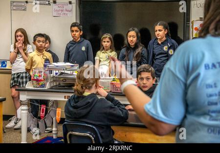 Auf Anregung ihres Lehrers diskutieren uniformierte multirassische Schüler an einer katholischen Mittelschule in Südkalifornien die Bücher, die sie als Gruppe gelesen haben Stockfoto