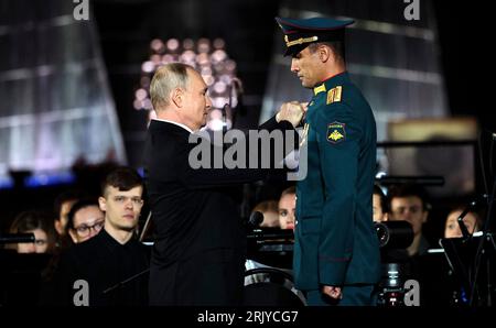 Ponyri, Russland. August 2023. Der russische Präsident Wladimir Putin verleiht dem Panzerkommandeur Rasim Baksikov während einer Galaveranstaltung zum 80. Jahrestag des Sieges in der Schlacht von Kursk während des Zweiten Weltkriegs am 23. August 2023 in Ponyri, Region Kursk, Russland, den russischen Helden der Russischen Föderation. Kredit: Maksim Blinov/Kreml Pool/Alamy Live News Stockfoto