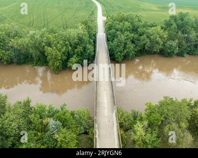 Straße und Brücke über den überfluteten Lamine River mit schwimmendem Schutt, Blick auf Roberts Bluff Access in Missouri Stockfoto