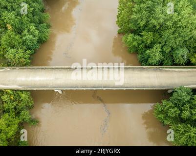 Straße und Brücke über den überfluteten Lamine River mit schwimmendem Schutt, Blick auf Roberts Bluff Access in Missouri Stockfoto