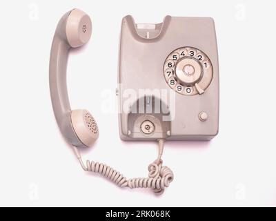 Ein graugrünes Drehtelefon ist auf weißem Hintergrund isoliert. Stockfoto