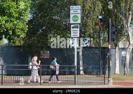 London, Großbritannien. Fußgänger gehen an einem Schild mit der Aufschrift „Low Emission Zone“ im Südwesten Londons vorbei. Stockfoto