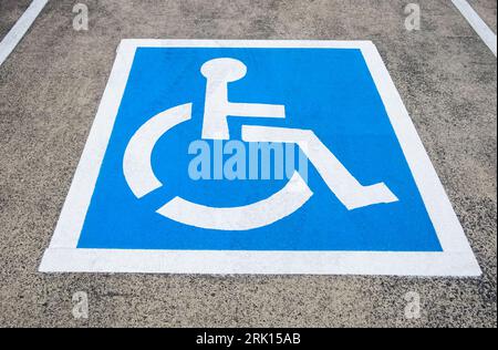 Reserviertes Parkschild für Behinderte. Behindertenparkplatz mit weiß blau lackiertem Schild für Behindertenparkplatz. Behindertenparkplatz, blau Stockfoto