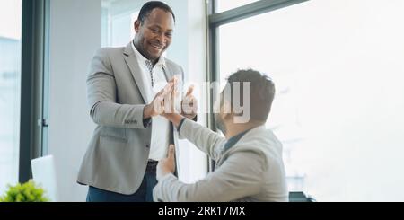 Two diverse businessman professionals celebrating teamwork in an office Stockfoto