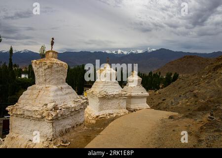Viele weiße Stupas in einer Reihe auf einem Berg mit blauem Himmel im Hintergrund Stockfoto