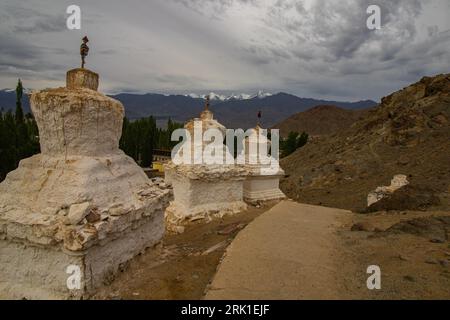 Viele weiße Stupas in einer Reihe auf einem Berg mit blauem Himmel im Hintergrund Stockfoto