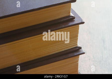 A stack of different old books for the background. Old books with yellowed pages lying one on top of another macro photo. Reading time.. Stockfoto