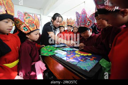 Bildnummer: 53326085 Datum: 04.09.2009 Copyright: imago/Xinhua (090908) -- KUNMING, 8. September 2009 (Xinhua) -- Eine Lehrerin der ethnischen Naxi-Gruppe unterrichtet ihre Schüler, wie man traditionelle Gemälde der Dongba-Kultur an einer Grundschule in Lijiang, Provinz Yunnan, am 4. September 2009 zeichnet. Lehrer der Naxi-ethnischen Gruppe in Lijiang führten die Dongba-Kultur, die traditionelle Kultur der Naxi-ethnischen Gruppe, den lokalen Schülern ein und lehrten ihnen Piktogramme, unterschiedliche Tänze, Musik und Gemälde. (Xinhua/Lin Yiguang) (zhs) (1)CHINA-YUNNAN-DONGBA-CULTURE (CN) PUBLICATIONxNOTxINxCHN Land un Stockfoto